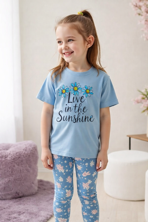 Child wearing a blue 'Live in the Sunshine' t-shirt with floral design.