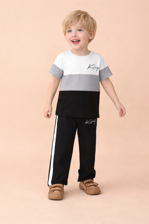Child wearing a two-tone shirt and black pants with white stripes on a beige background