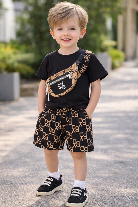 Child wearing a black t-shirt with a pattern, black shorts with gold design, and black shoes outdoors.