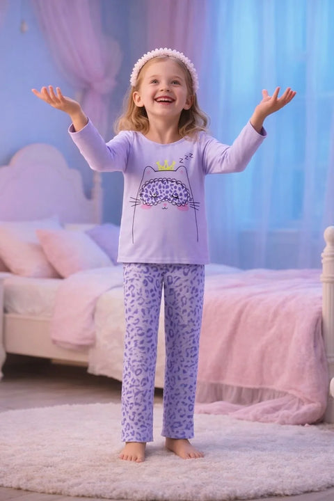 Young girl in a purple pajama set with a cat design in a bedroom.