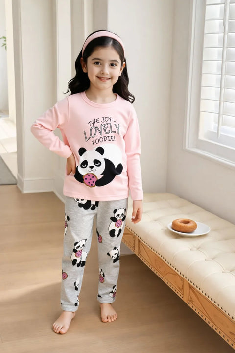 Child wearing pink and gray pajamas with panda design in a room.