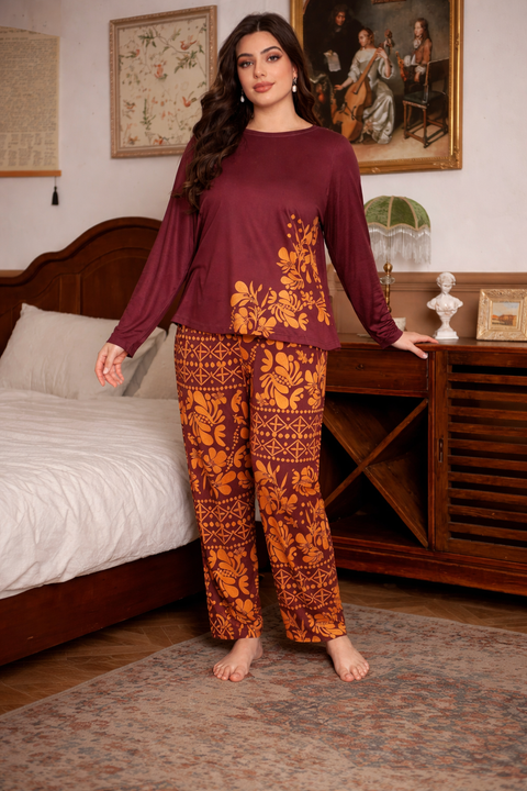Woman wearing a maroon top and orange floral pants in a bedroom setting.